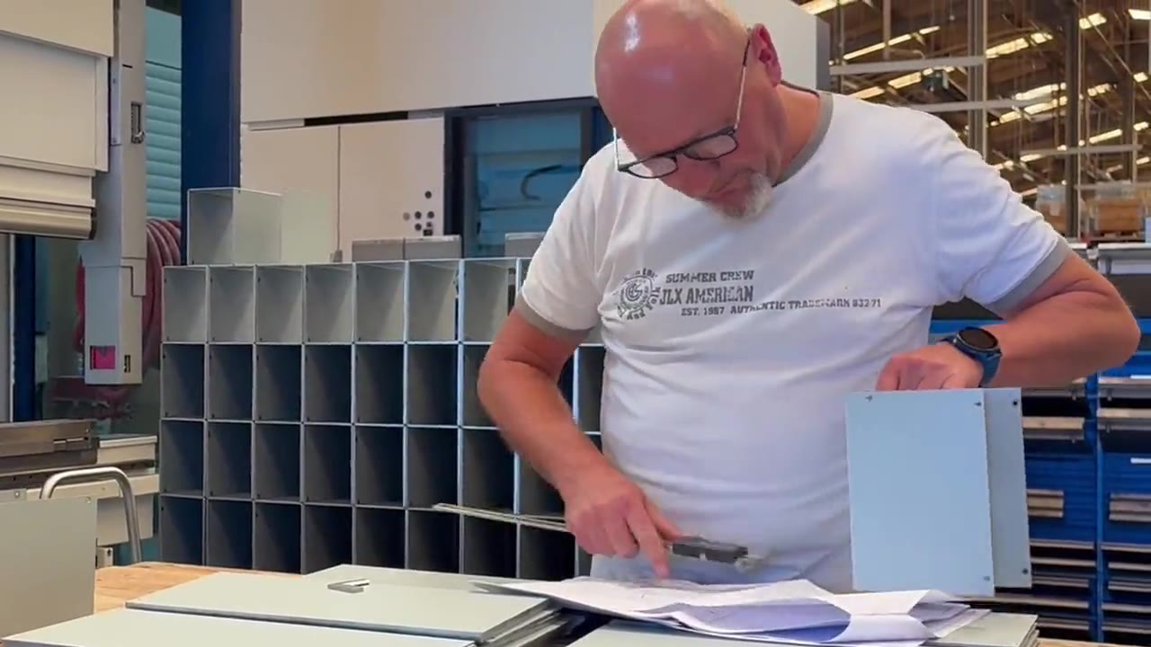 Contrôle qualité d'une pièce de tôlerie par l'opérateur au poste d'inspection chez Duflot à Holnon (Aisne, Hauts-de-France)