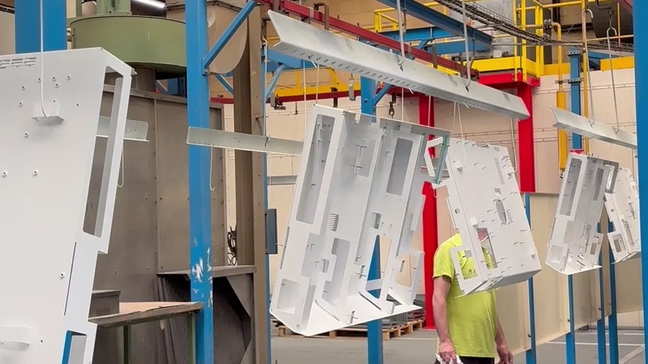 Peintre Duflot appliquant la finition poudre sur une pièce en cabine à Holnon (Aisne, Hauts-de-France)